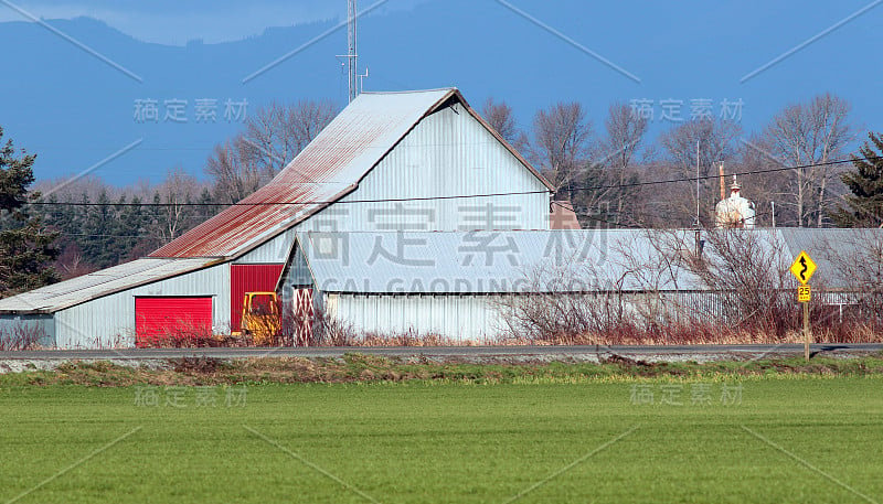 金属波纹谷仓与明亮的红色门