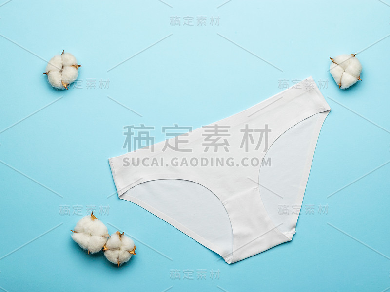 棉签和浅蓝色背景上的白色女性内裤。平的。