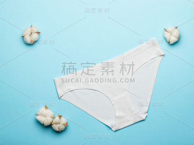 棉签和浅蓝色背景上的白色女性内裤。平的。
