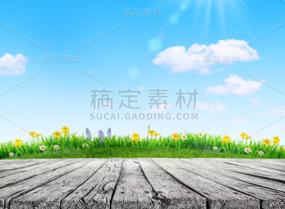 木桌和草地和春花田野模糊了背景