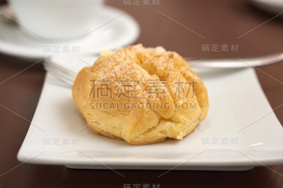 白色盘子上有奶油的圆烤泡芙蛋糕