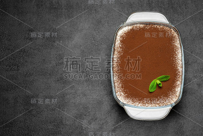 传统的意大利提拉米苏甜点在玻璃烤盘在混凝土背景