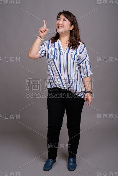 工作室拍摄的成熟美丽的亚洲女商人在灰色的背景