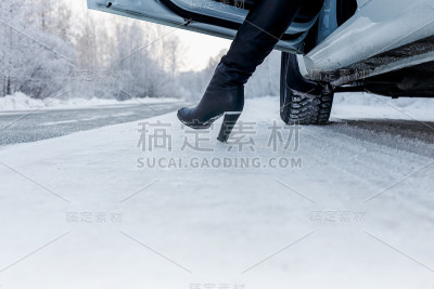 冬天的路线上，路上白色的车和女孩的腿