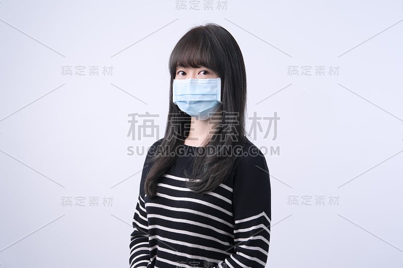 年轻的亚洲女性肖像，戴着医用外科蓝色口罩预防疫情，空气污染隔离白色背景。