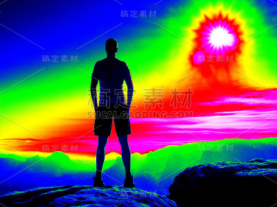 岩石山顶上的人。神奇的红外扫描。早晨雾谷