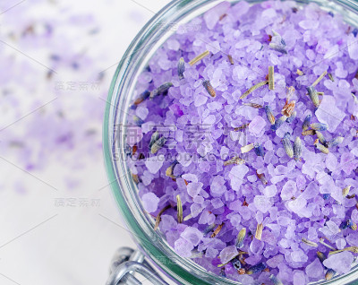 紫色浴盐(浸脚)与干薰衣草。俯视图，特写。