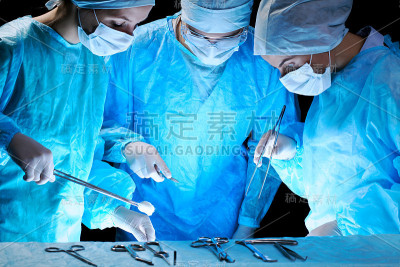 医疗队进行手术在手术室工作的一组外科医生，色调为蓝色