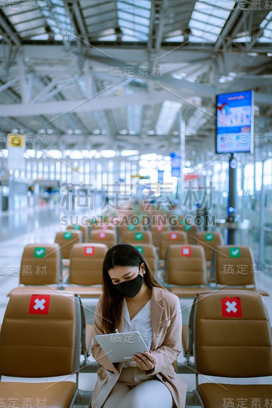 亚洲商务女乘客在机场使用她的数字平板电脑。