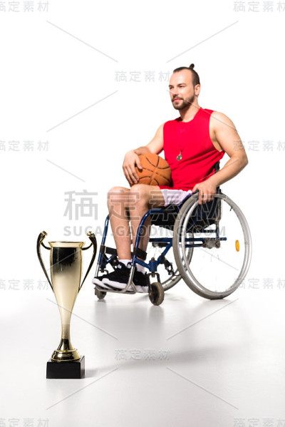 轮椅上拿着奖杯的运动员