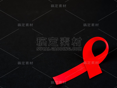 世界艾滋病日的概念。黑色背景上的红丝带。