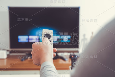 一个女人在客厅里拿着电视遥控器