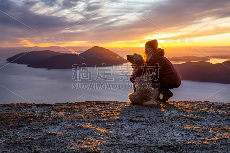 爱冒险的女孩带着狗在山顶徒步旅行