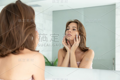 年轻女子在脸上擦面霜