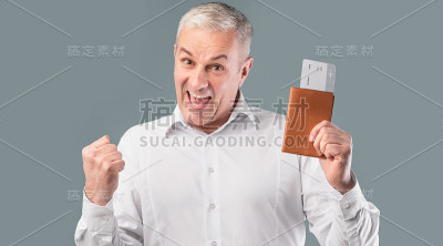 快乐的老人拿着机票和护照