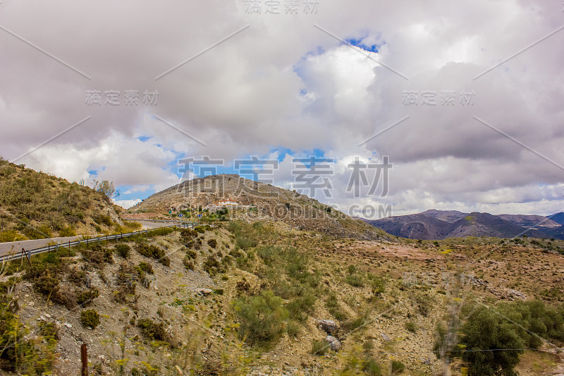 山景上的蓝色多云的天空背景。风景如画的群山在阳光下闪闪发光。令人屏息的自然影像