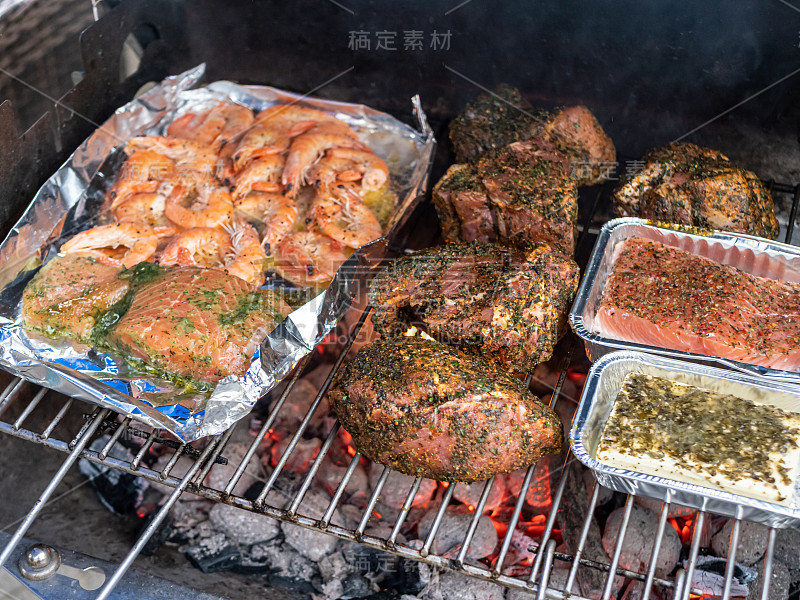 在花园里的木炭烤架上烤着肉和鱼