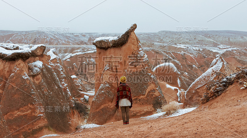 在卡帕多西亚德夫特山谷，一个女人独自面对雪景。