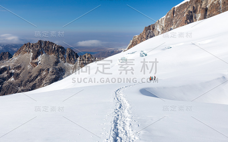 玻利维亚，登山者徒步攀登雪道山脊。