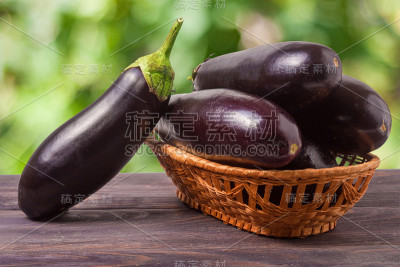 茄子在柳条篮子里的木桌上模糊不清