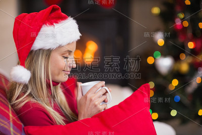 金发碧眼，戴着圣诞帽，手里拿着杯子