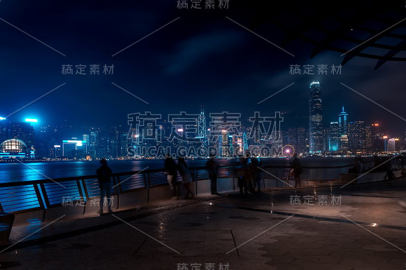 香港城市夜景。在海滨散步的游客