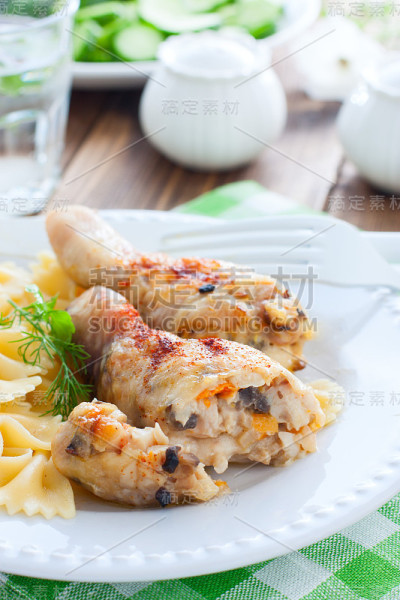 香槟酒鸡腿夹在白色的盘子里，配上意大利面，选择性聚焦