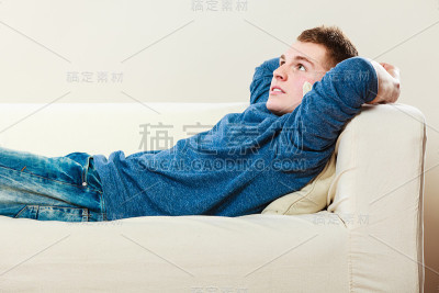 坐在沙发上沉思的年轻人