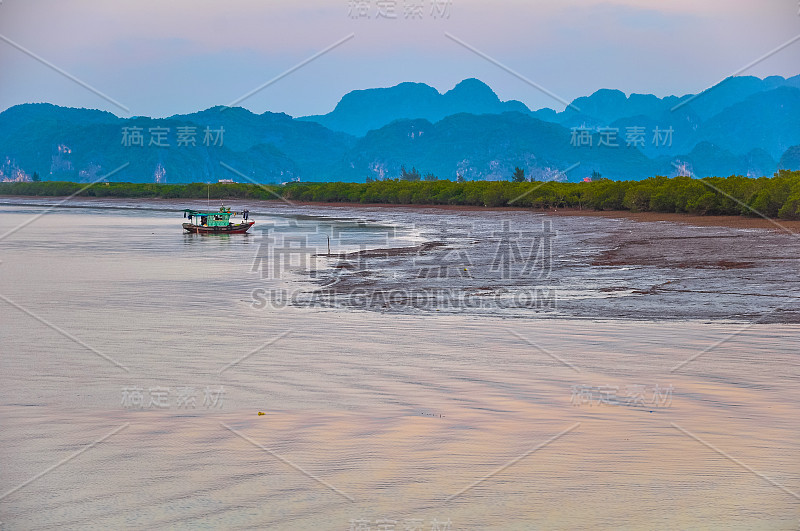 退潮时，一艘小船停在小岛的海湾里