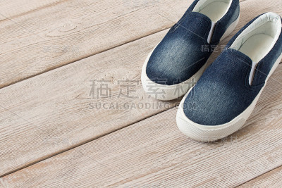 粗斜纹棉布拖鞋上的木制背景。前视图。