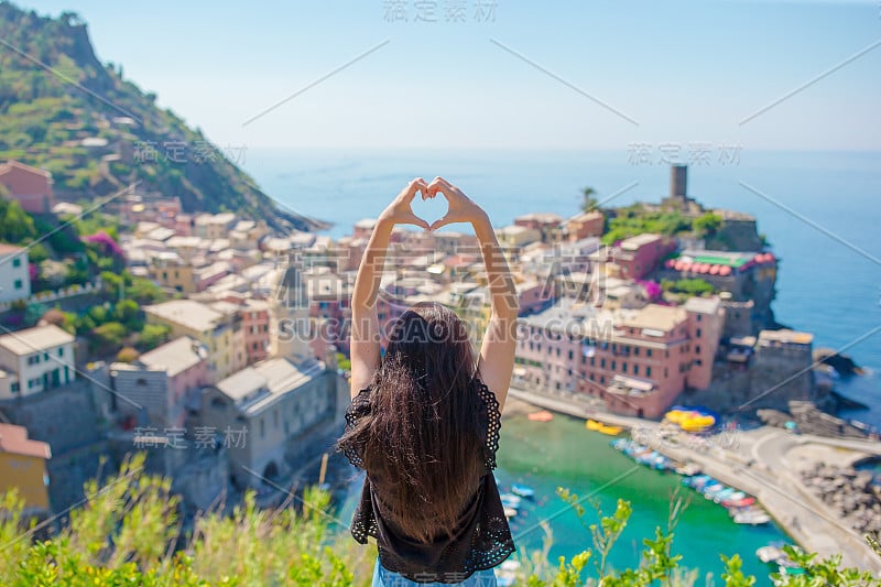 美丽的女孩用手在古老的海滨小镇Vernazza的背景，五Terre国家公园，利古里亚，意大利，欧洲