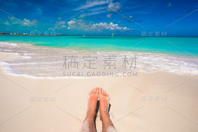 女性的脚在白色的沙滩上的特写