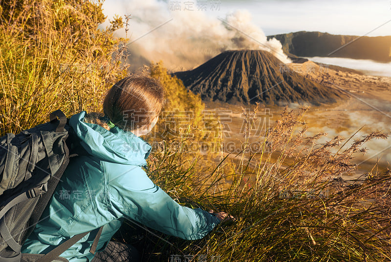 女背包客在山中旅行，欣赏风景火山