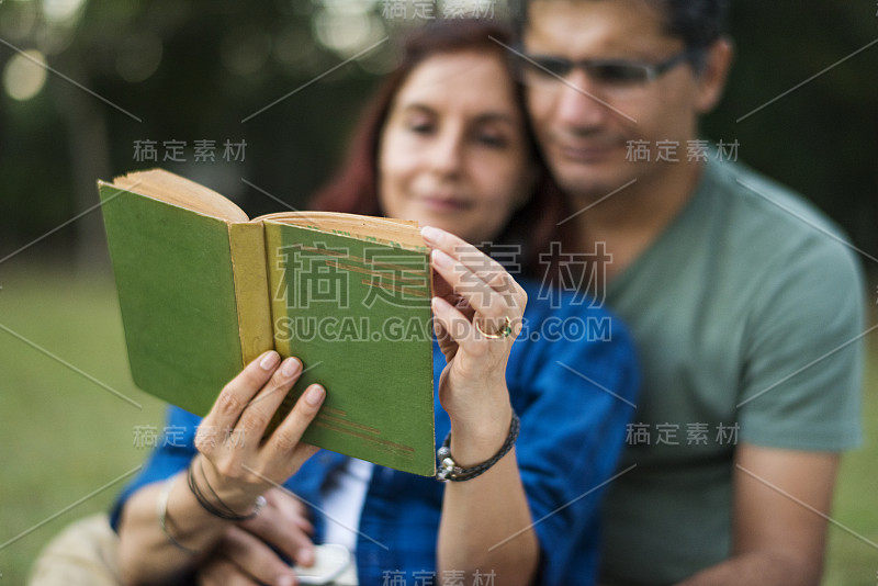 一对夫妇花时间一起阅读小说在丛林野餐