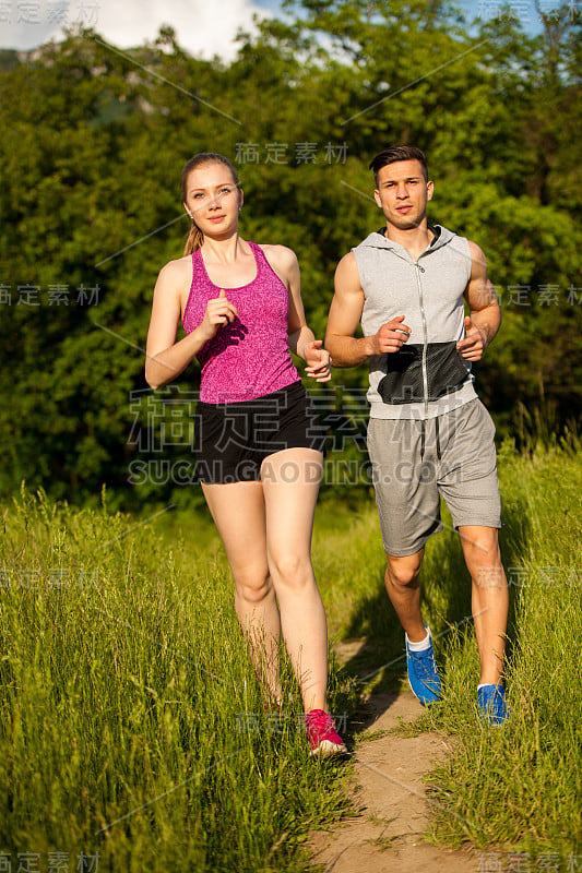 活跃的年轻夫妇在公园里跑步