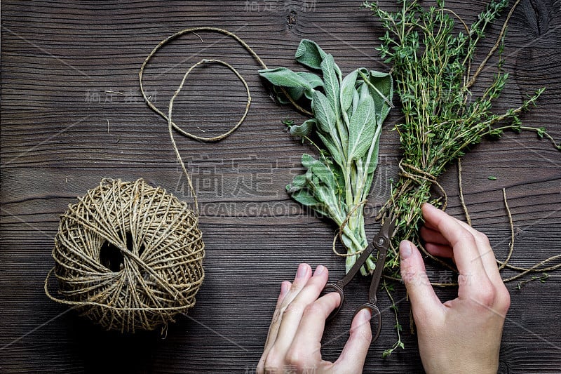 百里香和鼠尾草木制背景与手俯视图