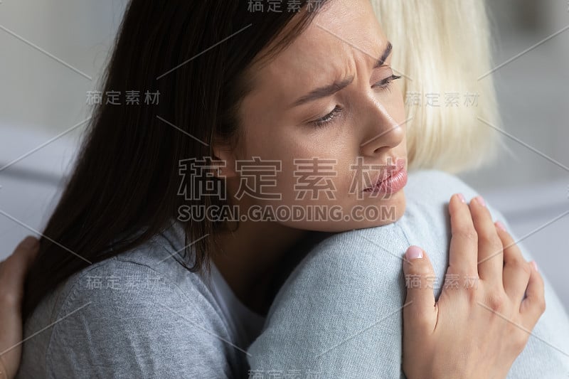 沮丧的妈妈和成年的女儿拥抱表示支持和关心