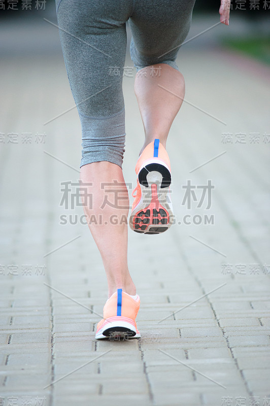 运动员的脚跑在道路上的鞋子特写。女性健身慢跑健身健康理念。