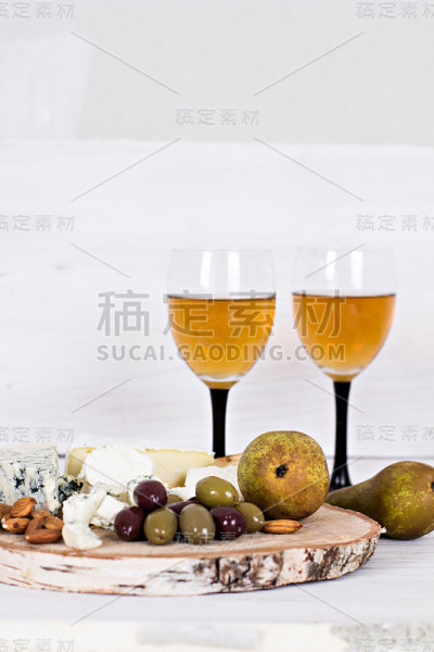 白葡萄酒和零食。葡萄酒，葡萄，奶酪，坚果，橄榄。浪漫的夜晚，静物。