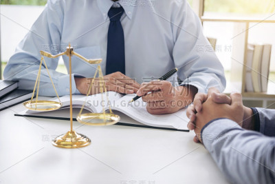 法官拿着正义的天平，商界人士和男律师在律师事务所讨论合同文件。法律的概念