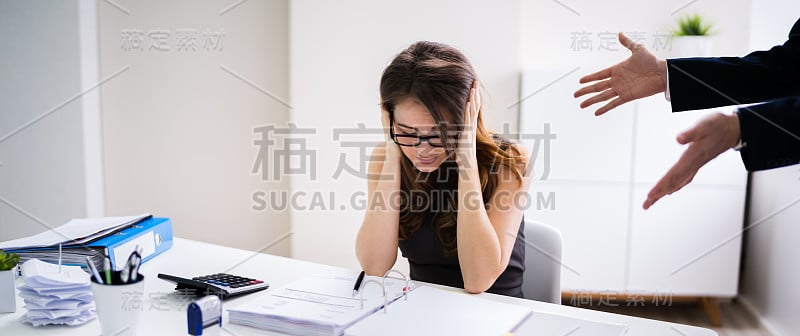 老板对坐在办公桌前的员工大喊大叫