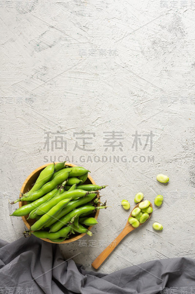 新鲜的蚕豆带豆荚，乡村背景，健康食品