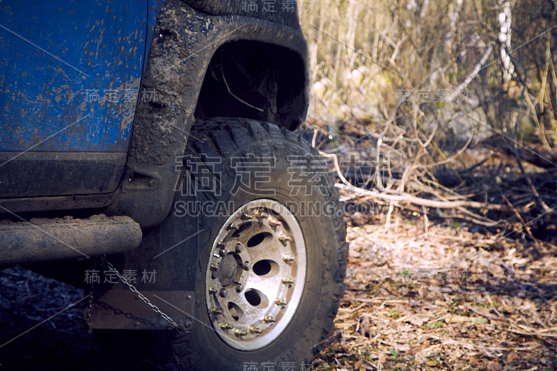 乘坐蓝色4x4轿车在森林公路上越野。