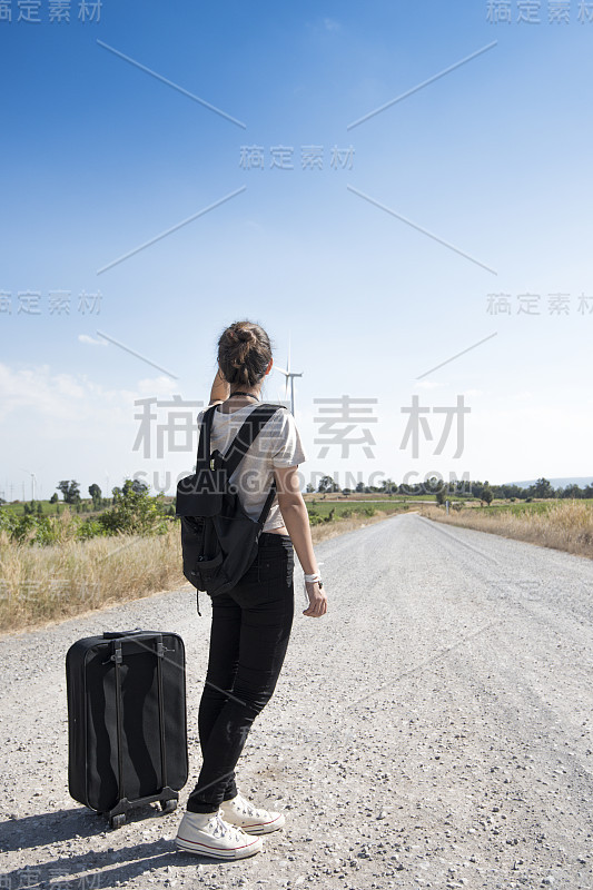 年轻女孩带着包旅行等公共汽车