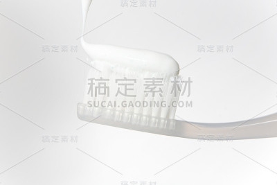 白色牙膏上的牙刷明亮特写。