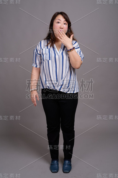 工作室拍摄的成熟美丽的亚洲女商人在灰色的背景