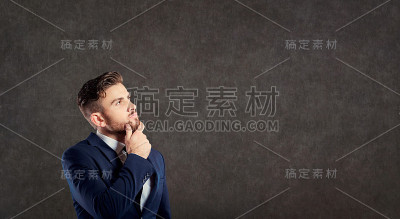 一位穿着西装的年轻男性商人正在思考