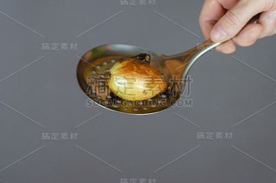 一只手拿着一串带血清的烤蔬菜。一个皮