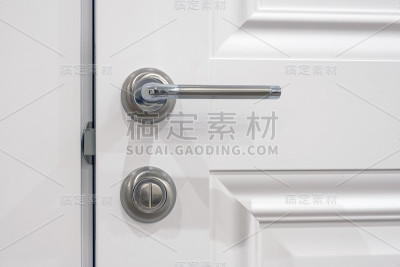 金属把手和旋转锁在一个白色半开的门上，关闭。法国普罗旺斯风格的元素门