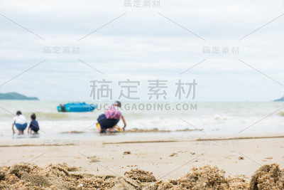 一个亚洲家庭在沙滩上玩耍